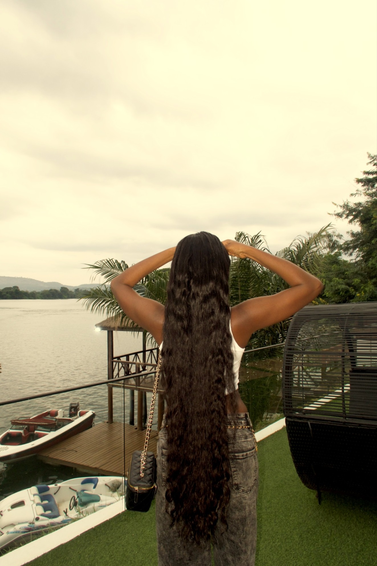 Waist-length deep wave hair seen from behind, by the lake